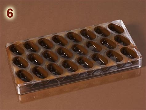 Gefüllte Pralinenhohlkörper in Form mit Kuvertüre verschließen