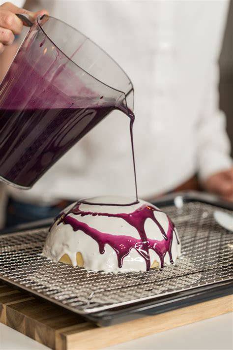 Gefrorene Torte auf Gitter beim Übergießen mit Mirror Glaze