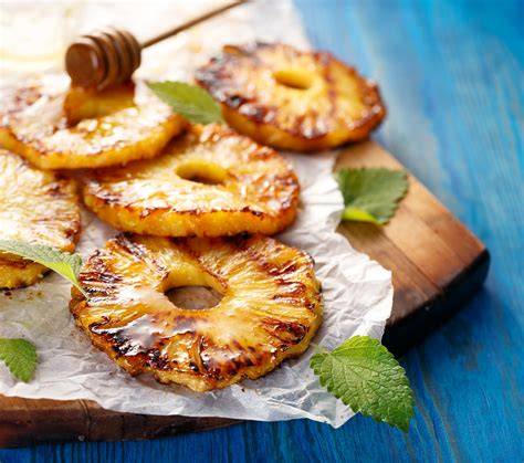 Gegrillte Ananasscheiben mit gerösteten Kokosraspeln