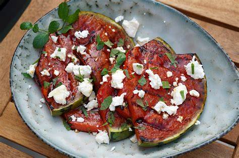 Gegrillte Melone mit Feta und Minze angerichtet