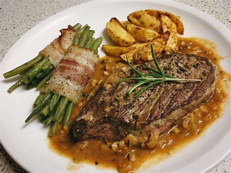 Gegrilltes Steak mit Beilagen Kartoffelsalat und Bohnen