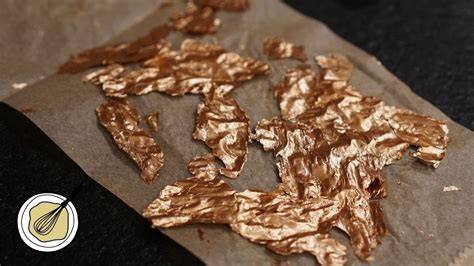 Gehackte Pistazien und essbares Blattgold auf Schokolade
