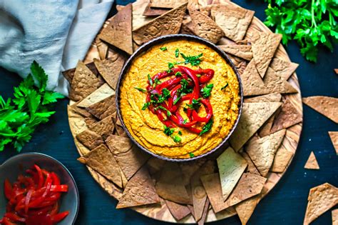 Gemüsechips und Hummus auf einem Holzbrett