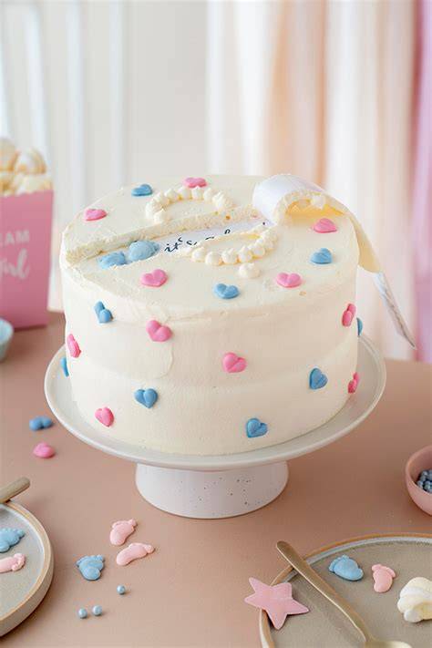 Gender Reveal Torte mit blau-rosa Tupfen und Zuckerperlen dekoriert