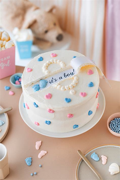 Gender Reveal Torte mit rosa und blauer Dekoration und Schleifen
