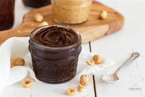 Geröstete Haselnüsse und ein Glas selbstgemachte Nuss-Nougat-Creme