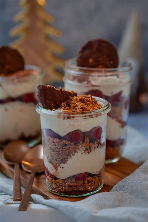 Geschichtete Desserts im Glas mit Lebkuchen und Kirschen