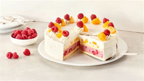 Geschichtete Quark-Sahne-Torte mit bunten Früchten garniert