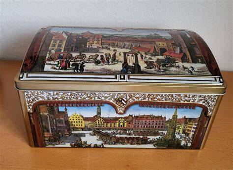 Geschlossene Blechdose mit Lebkuchen und Apfelstück auf Alufolie