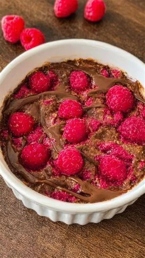 Gestürzte Schokoladencreme auf Teller mit Himbeeren