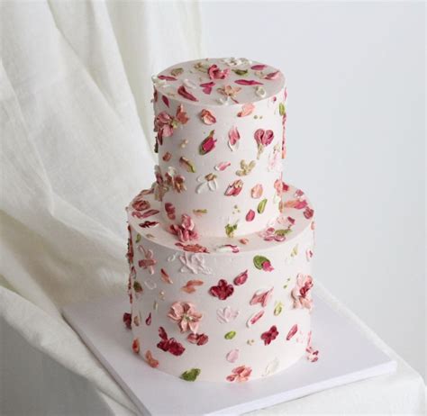 Gestapelte Hochzeitstorte mit Erdbeeren und essbaren Blüten
