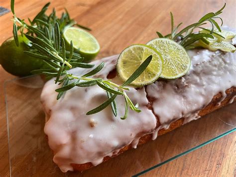 Gin Tonic Kuchen auf Teller, mit kandierten Limetten und Rosmarin dekoriert