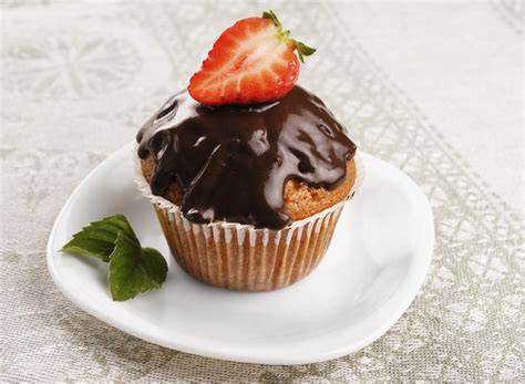 Glänzende Schokoglasur auf frisch gebackenen Muffins, Nahaufnahme mit Tropfen