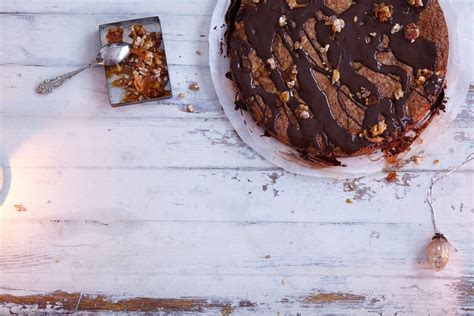 Glänzende Schokoladenglasur auf Kuchen mit gehackten Nüssen