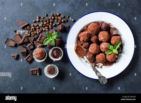 Gläser Espresso-Kirsch-Marmelade auf Frühstückstisch, Kaffeebohnen und dunkle Schokolade