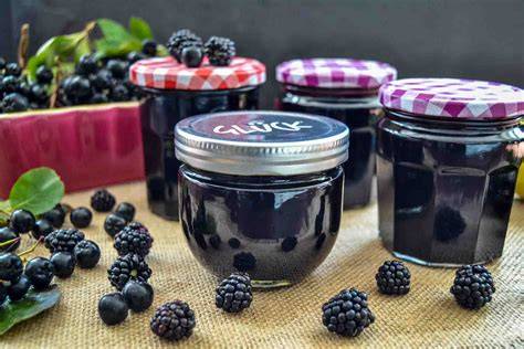 Gläser mit Brombeer-Ingwer-Marmelade und frische Brombeeren