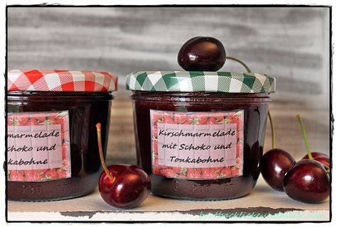Gläser mit Erdbeer-Schoko- und Kirsch-Schoko-Marmelade, Zutaten und Kochutensilien