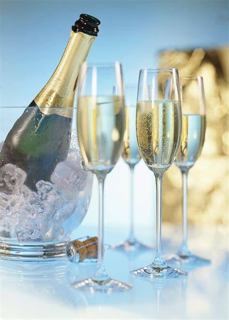Gläser mit Holunderblüten-Sekt-Gelee, daneben Zitrone und Sektflasche