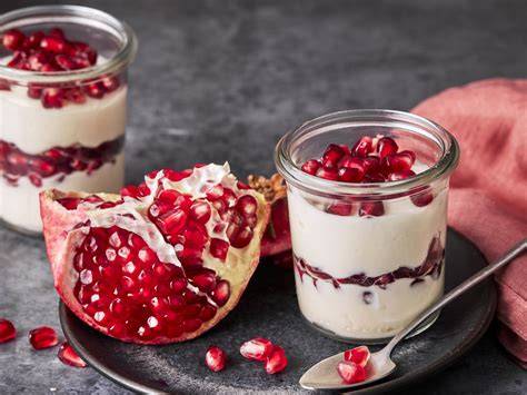 Gläser mit Joghurtcreme, Granatapfelkernen und Pinienkernen