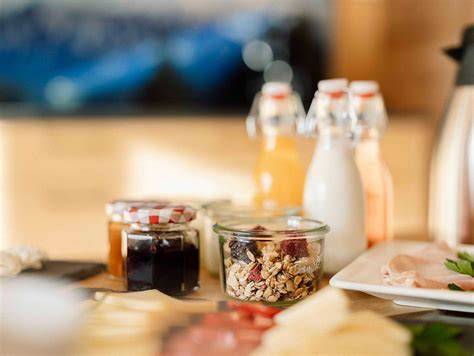 Gläser mit Mirabellen-Bananen-Marmelade auf dem Frühstückstisch