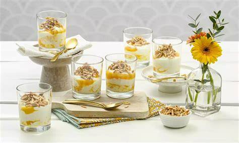 Gläser mit Quark-Pfirsich-Dessert und karamellisierten Mandeln