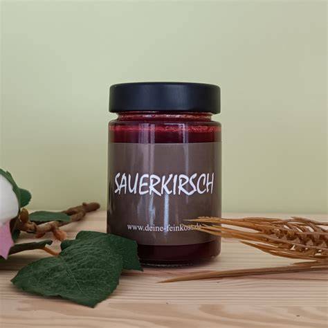 Gläser mit Sauerkirsch-Marmelade und Mon Chérie auf einem Frühstückstisch