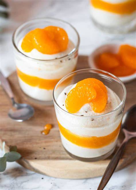Gläser mit Schichten aus Butterkeks, Quark-Sahne-Creme und Mandarinen