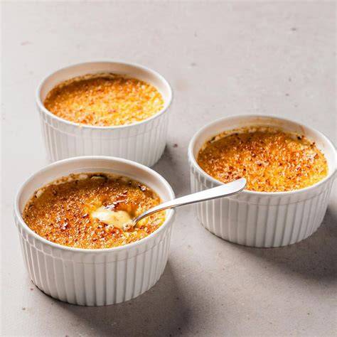 Gläser mit Schichten aus Kompott, Creme und karamellisierter Zuckerkruste