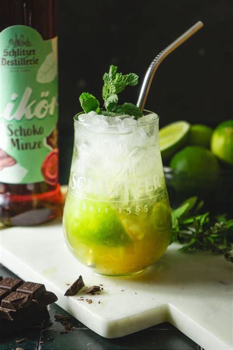 Gläser mit Schoko-Minz-Schichten, daneben frische Minze und Raspelschokolade