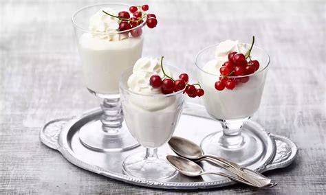 Gläser mit Spekulatius-Kirsch-Dessert verziert mit Sahnetupfen und Spekulatiusstücken
