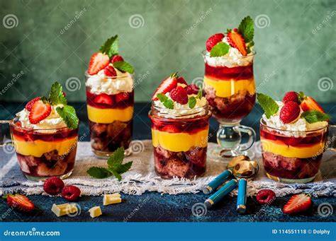 Gläser mit bunten Trifles: Kuchen, Pudding und Beeren geschichtet