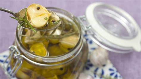 Gläser mit eingemachtem Knoblauch und Kräutern