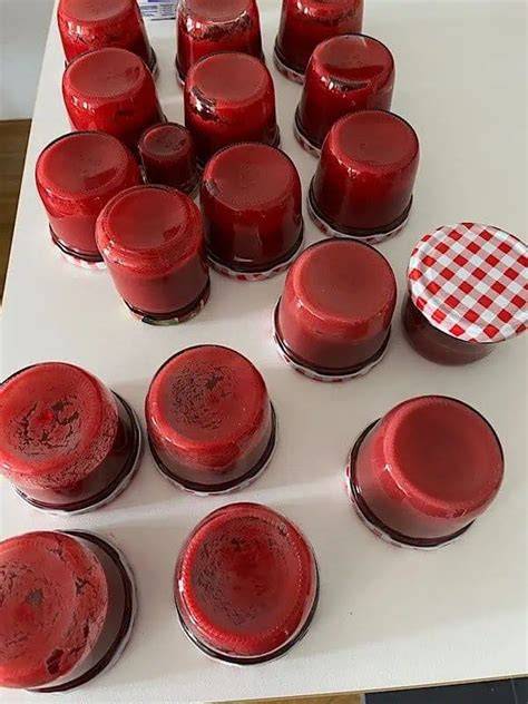 Gläser mit frisch eingekochter Melonen‑Marmelade auf einem Handtuch