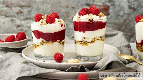 Gläser mit geschichtetem Joghurt und Himbeeren