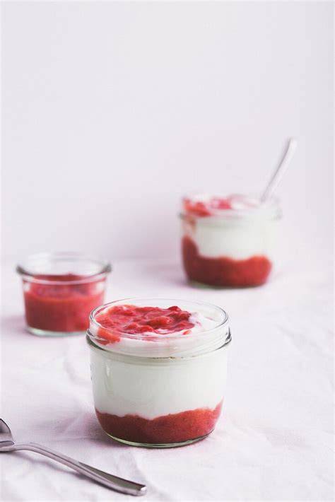 Gläser mit geschichtetem Joghurtdessert und Beeren