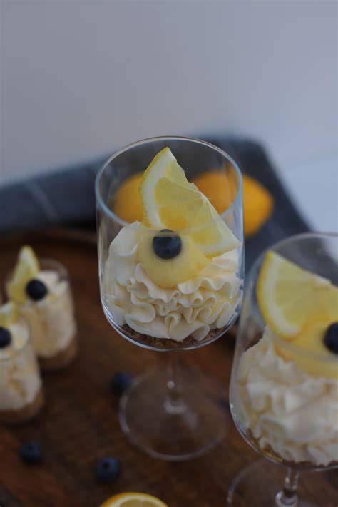 Gläser mit geschichtetem Lemon Cheesecake und Zitronenscheiben