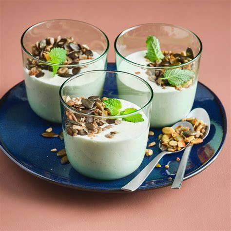 Gläser mit geschichteten Mohn-Desserts: Creme, Fruchtpüree, Granola