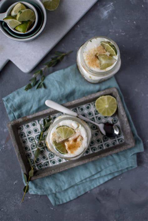Gläser mit geschichteter Limetten-Joghurtcreme und kandierter Limettenschale als Topping