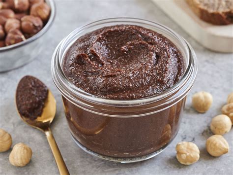 Gläser mit selbstgemachtem Schokoaufstrich auf Holzbrett