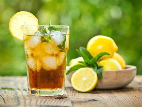 Glas Eistee mit Minze und Zitrone auf einem Tisch im Sommer