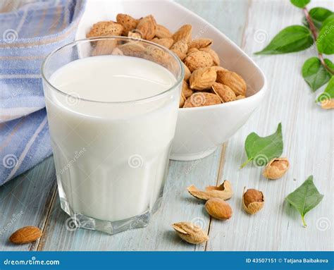 Glas Mandelmilch und Honig neben Mandeln