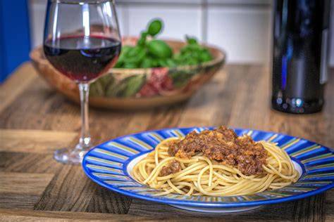 Glas Rotwein neben einem Teller Trüffelpasta