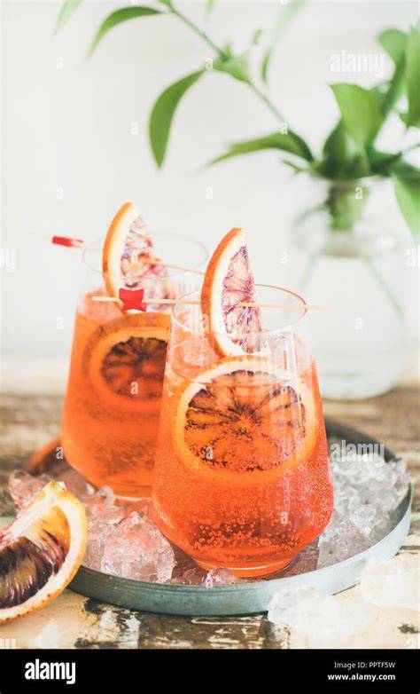 Glas mit Aperol Spritz und frische Orangen
