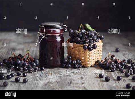 Glas mit Aronia-Johannisbeer-Marmelade und frischen Beeren