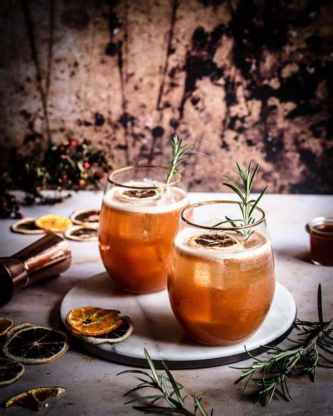 Glas mit Kräuterhonig und frischem Rosmarin am Rand