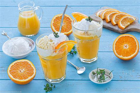 Glas mit Orangensaft, Vanilleeis und Schlagsahne