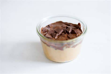 Glas mit cremigem Dulce de Leche auf Brot