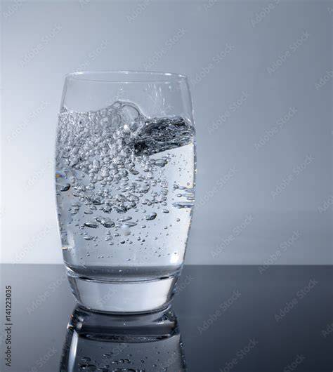 Glas mit erfrischendem Sprudelwasser und Sirup, Limettenscheibe