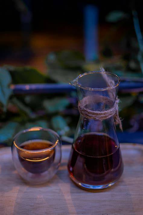 Glas mit fertigem Trunk neben Tasse Tee