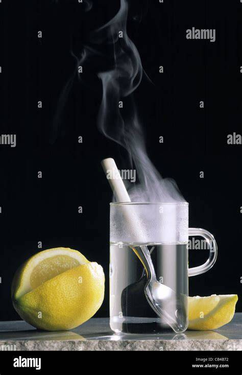 Glas mit heißem Zitronenwasser und Honiglöffel